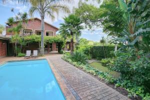 a swimming pool in front of a house at Aziza Guest House in George