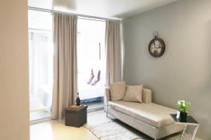 a living room with a couch and a clock on the wall at GM Rentals SafeStay Apartment at Mactan Airport in Mactan