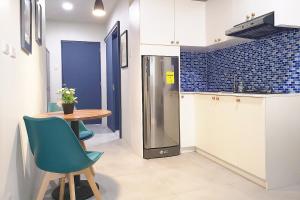 a kitchen with a table and a refrigerator at GM Rentals SafeStay Apartment at Mactan Airport in Mactan