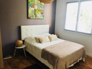 a bedroom with a bed with a white bedspread and a window at CosyStudio2 Site du Futuroscope in Jaunay-Marigny