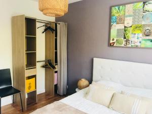 a bedroom with a white bed and a painting on the wall at CosyStudio2 Site du Futuroscope in Jaunay-Marigny