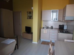 une cuisine aux murs jaunes et une petite cuisine avec cuisinière dans l'établissement Casavacanze Residence Maia Volcani, à Acireale