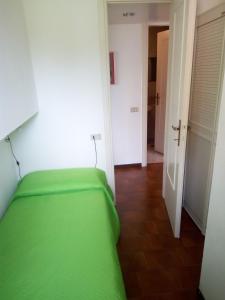 una camera con letto verde e corridoio di La Terrazza a Stresa