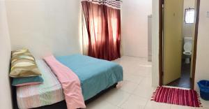 Kleines Zimmer mit einem Bett und einem Bad. in der Unterkunft Lily Homestay @ Kangar, Perlis in Kangar