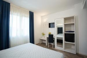 1 dormitorio con cama, escritorio y espejo en Guest House DOLCE LAGUNA 2, en Tessera