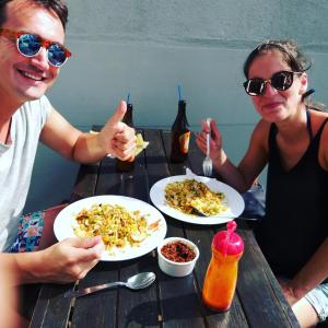 two people sitting at a table with plates of food at I & I Hostel in Mirissa