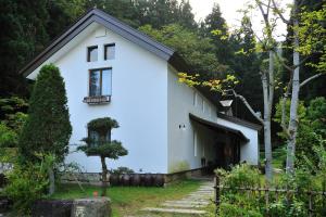 una casa blanca con techo negro en Meigetsuso, en Kaminoyama