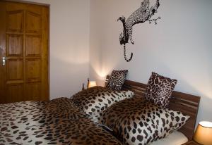 een slaapkamer met twee bedden en een luipaard op de muur bij s'Schnoganeschd in Nemesvid +28 foto's