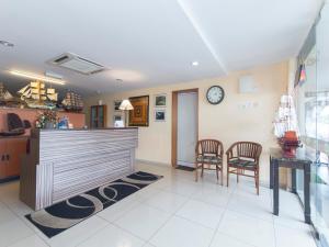 a lobby with two chairs and a clock on the wall at Straits Settlement Inn in Melaka