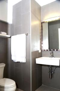 een badkamer met een toilet, een wastafel en een spiegel bij Casa Alessandra 1bdr in Palm-Eagle Beach