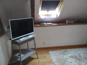 a computer monitor on a desk in a room with a mirror at Kericouette et Délices in Le Vieux-Bourg