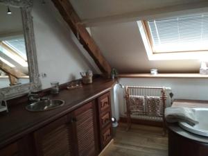 a bathroom with a sink and a mirror at Kericouette et Délices in Le Vieux-Bourg
