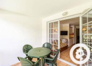 a dining room with a green table and chairs at N111, parc d'arradoy-St Jean Pied de Port in Uhart-Cize