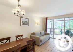 a living room with a couch and a dining room table at N111, parc d'arradoy-St Jean Pied de Port in Uhart-Cize