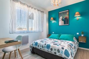 アングレットにあるConfort-Appartement Cosy Miladyの青い壁のベッドルーム1室、ベッド1台、デスクが備わります。