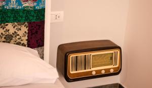 an old radio sitting on the side of a bed at S'accabbadora Guest House in Alghero