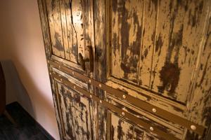 an old wooden door in a room at S'accabbadora Guest House in Alghero