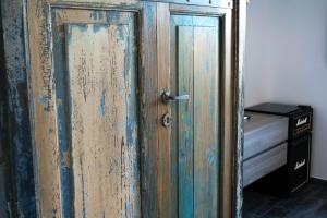 an old wooden door in a room with a bed at S'accabbadora Guest House in Alghero