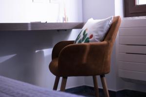 a chair with a pillow on it in a room at S'accabbadora Guest House in Alghero
