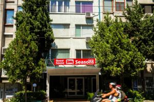 two people riding a motorcycle in front of a building at Sezoni South Burgas in Burgas City