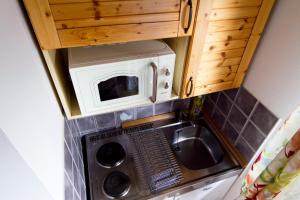 a small kitchen with a microwave and a washing machine at Chatka 428 a 429 - Tatralandia in Liptovský Mikuláš