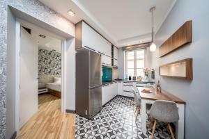 a kitchen with a table and a refrigerator at Apartment PREMIUM Old Town by Your Freedom in Warsaw