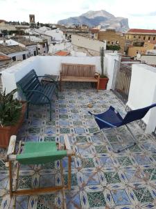 d'une terrasse avec des chaises et un banc sur le sol de carrelage. dans l'établissement Casa in palazzo Graffeo Sven, à Palerme