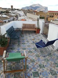 patio z krzesłami i ławką na podłodze. w obiekcie Casa in palazzo Graffeo Sven w mieście Palermo