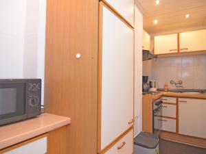 a kitchen with a microwave and a tv on a counter at Apartment in Sauerland with terrace in Helminghausen