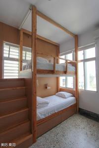 een slaapkamer met 2 stapelbedden en een trap bij Mayhow Donghe in Donghe