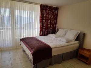 Cama en habitación con ventana y visor en Route du Village 5 Residence Panorama, en Villars-sur-Ollon 33 fotos más