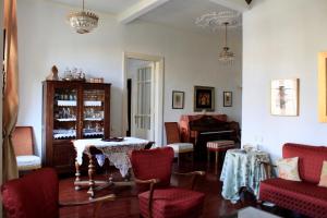 a living room with a table and chairs and a piano at City Center Landmark House in Thessaloniki