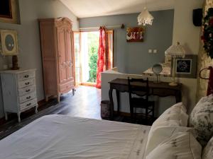 um quarto com uma cama, uma secretária e uma mesa em Le Duplex de Lapparan em Saint-Drézéry