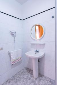 Baño blanco con lavabo y espejo en Apartamentos Las Casitas en Frontera