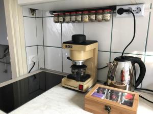 a coffee maker sitting next to a box on a counter at Orchidea Vendégház - Zebegény in Zebegény