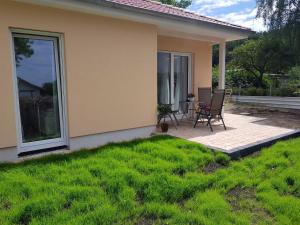 eine Terrasse mit 2 Stühlen und einem Tisch vor einem Haus in der Unterkunft Ferienwohnung Inselglück in Ahlbeck