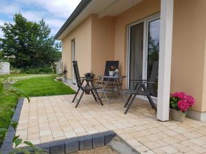 eine Terrasse mit einem Tisch und Stühlen neben einem Haus in der Unterkunft Ferienwohnung Inselglück in Ahlbeck