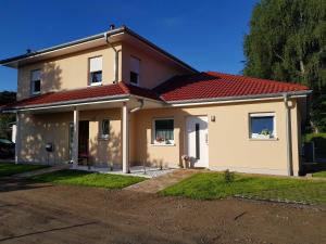 ein weißes Haus mit einem roten Dach in der Unterkunft Ferienwohnung Inselglück in Ahlbeck