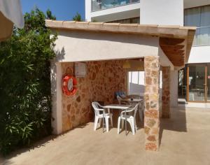 a patio with tables and chairs in a building at Apartamentos Villa Primera in Cala Figuera
