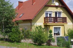 a yellow house with a red roof at Domek Górski Strumień in Stronie Śląskie