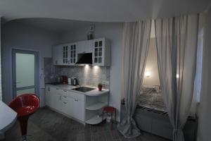 a kitchen with a sink and a bed in a room at Уютная Студия на Парковой 29 in Sevastopol