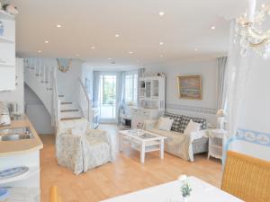 a living room with a couch and chairs and a staircase at Haus Midsommer in Timmendorfer Strand