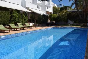a large swimming pool with chairs and a building at miKasa Agua Amarga & SPA in Agua Amarga