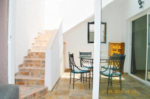 a dining room with a staircase and a table and chairs at New renovated duplex near the ocean located in Tenerife Sur in Costa Del Silencio