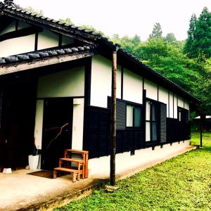 a black and white building with a bench in front of it at Yamatosaryo in Yamato