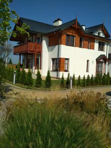 ナウェンチュフにあるApartament Zdrojowyの黒屋根の大白い家