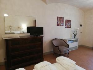 - une chambre avec une commode, une télévision et un miroir dans l'établissement Villa Casupoli, à Castiglion Fiorentino