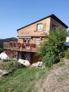 Una casa con una terraza con flores. en Le Gite Du Bucheron, en Dabo