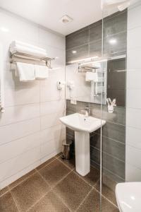 a white bathroom with a sink and a shower at Mount Inn Kazbegi in Kazbegi