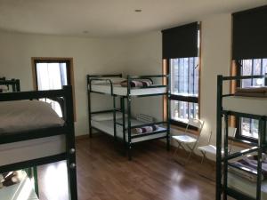 a room with three bunk beds and two windows at Linar Do Rei in Linares